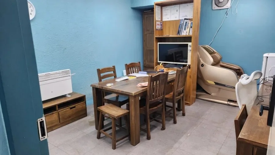 파란 벽과 나무 상담 테이블이 있는 소라공인중개사사무소 전경